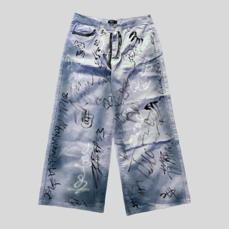 Light blue washed wide-leg jeans covered with black and grey handwritten graffiti-style graphics and abstract sketch markings.