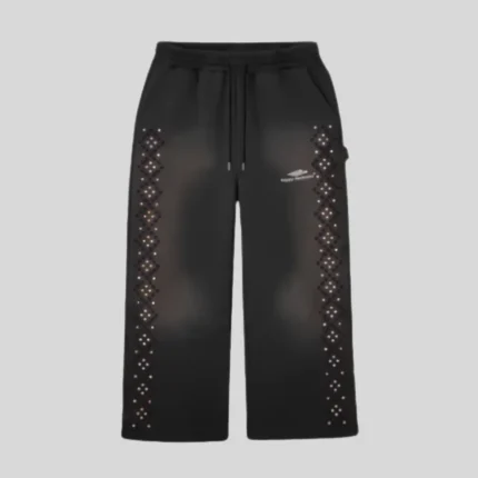 Black relaxed-fit sweatpants featuring geometric sparkling rhinestone embellishment along both outer legs and a small light-colored graphic on the upper thigh.
