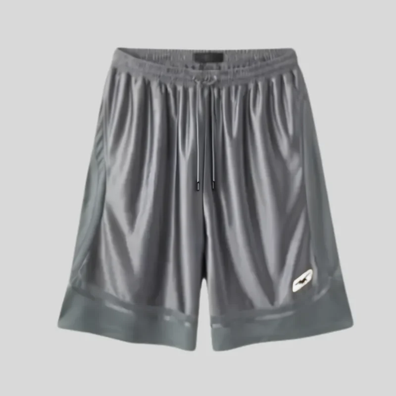 Charcoal grey wide-leg sweat shorts with elastic waistband, adjustable drawstring and subtle white side logo.