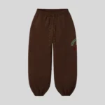 Brown relaxed fit sweatpants with adjustable drawstring waist, elastic cuffs and multicolor graphic detail on the upper leg.