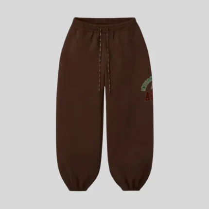 Brown relaxed fit sweatpants with adjustable drawstring waist, elastic cuffs and multicolor graphic detail on the upper leg.