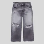 Grey washed distressed jeans with frayed ripped knees and rhinestone embellishments running along both outer legs.