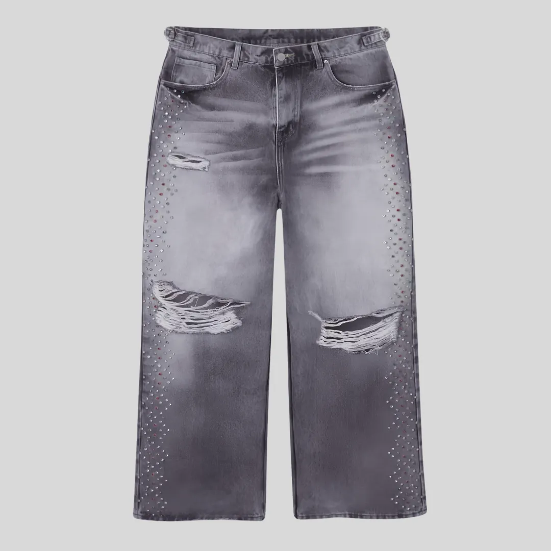 6 Grey washed distressed jeans with frayed ripped knees and rhinestone embellishments running along both outer legs.