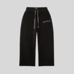 Black relaxed fit sweatpants with adjustable white drawstrings and subtle graphic text detail on the upper leg.