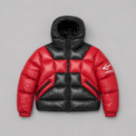Red and black color block puffer jacket with large hood, quilted construction, front zipper, angled zip pockets, elastic cuffs and white sleeve logo.